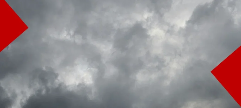 Vue d'un ciel couvert d'épais nuages gris orageux et tourbillonnants, encadrée par deux formes géométriques rouges triangulaires en haut à gauche et en bas à droite.