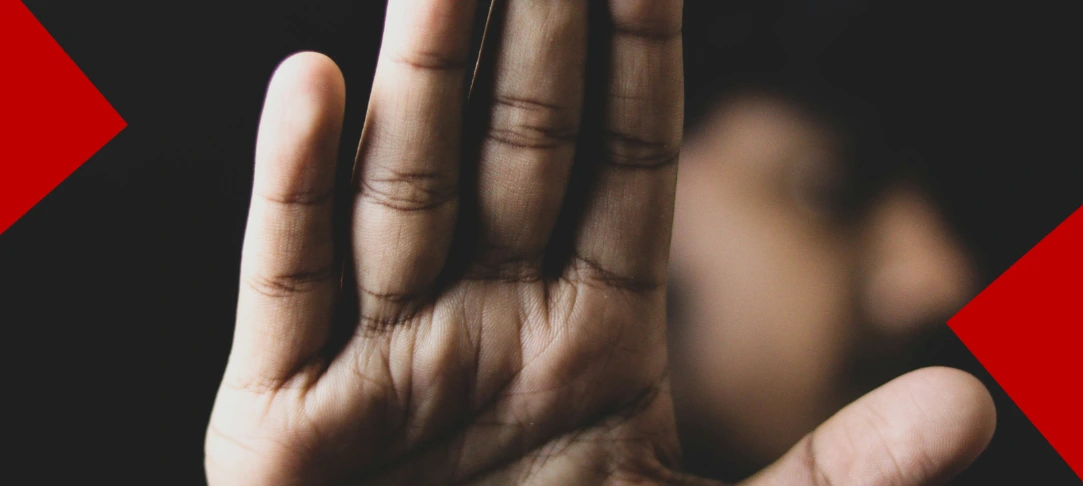 Gros plan sur la paume d'une main d'homme levée vers l'avant en signe de stop ou de protestation, devant un visage flou en arrière-plan. Le fond est noir avec deux formes géométriques rouges sur les côtés