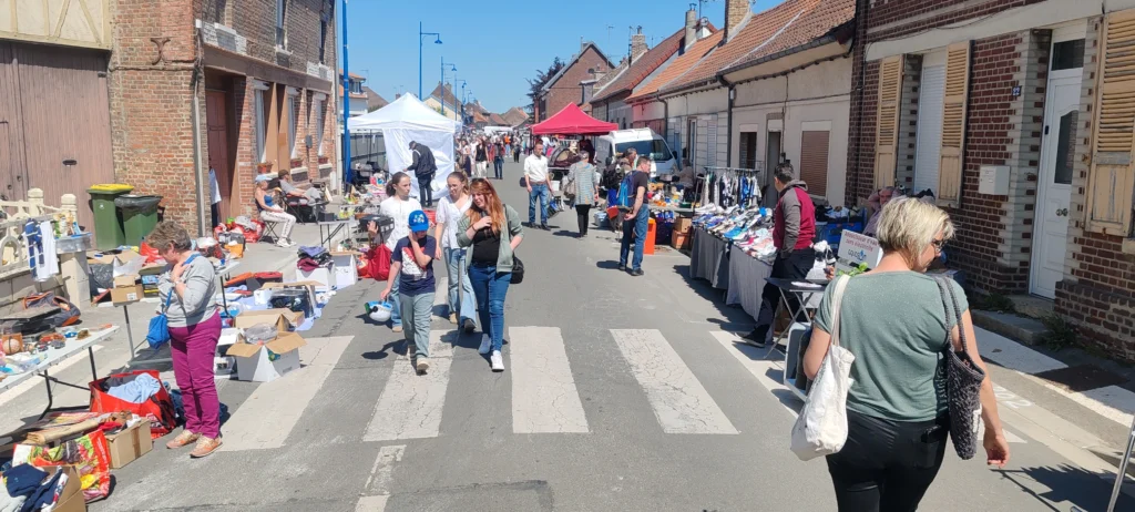 Des visiteurs se promènent en famille, tandis qu'une dame semble être attirée par un objet. 