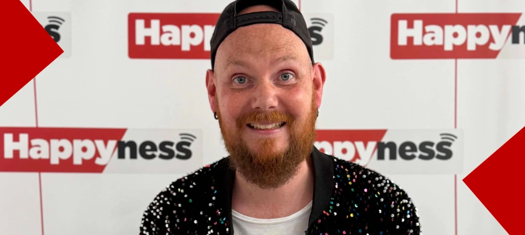 Portrait du DJ amiénois Marcus souriant dans les studios de la radio Happyness, portant une casquette noire à l'envers et une veste à paillettes.