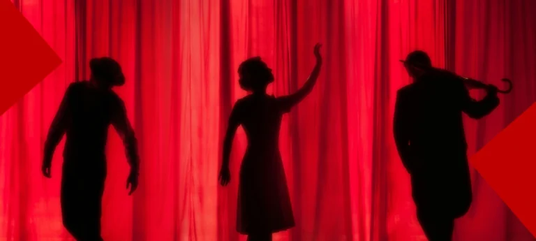 Silhouette de trois artistes sur scène devant un rideau de théâtre rouge vif. À gauche, un homme avec un chapeau et une veste est courbé. Au centre, une femme en robe lève la main vers le ciel. À droite, un homme en queue-de-pie tient une canne. De grands triangles rouges décorent les angles supérieurs et inférieurs.