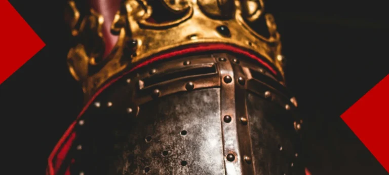 Gros plan sur un heaume de chevalier en métal martelé, surmonté d'une couronne dorée ornée de pierres sombres. L'image est encadrée par deux formes géométriques rouges sur un fond noir.